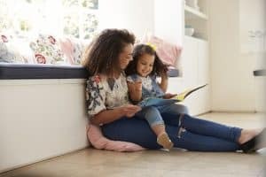 A woman reading to a young girl.