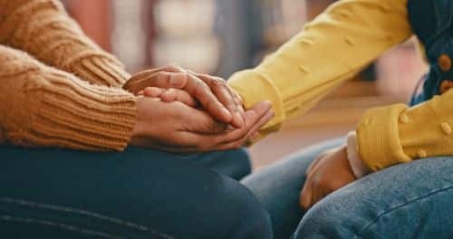 a guardian holding hands with their loved one.